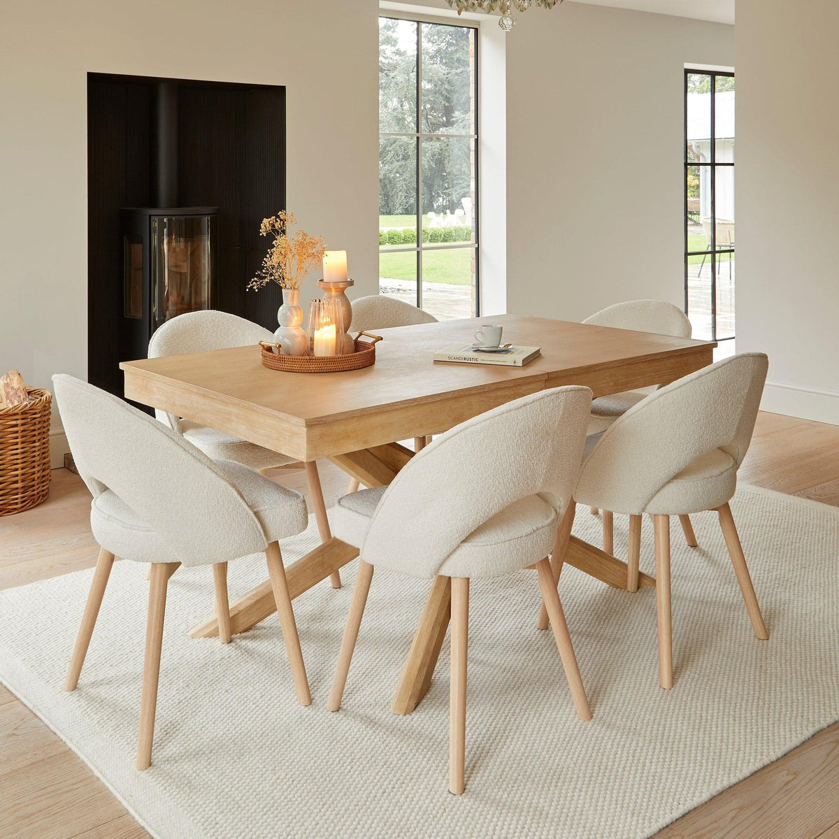 Light cream textured rug beneath a wooden dining table with upholstered chairs in a bright, elegant dining room.